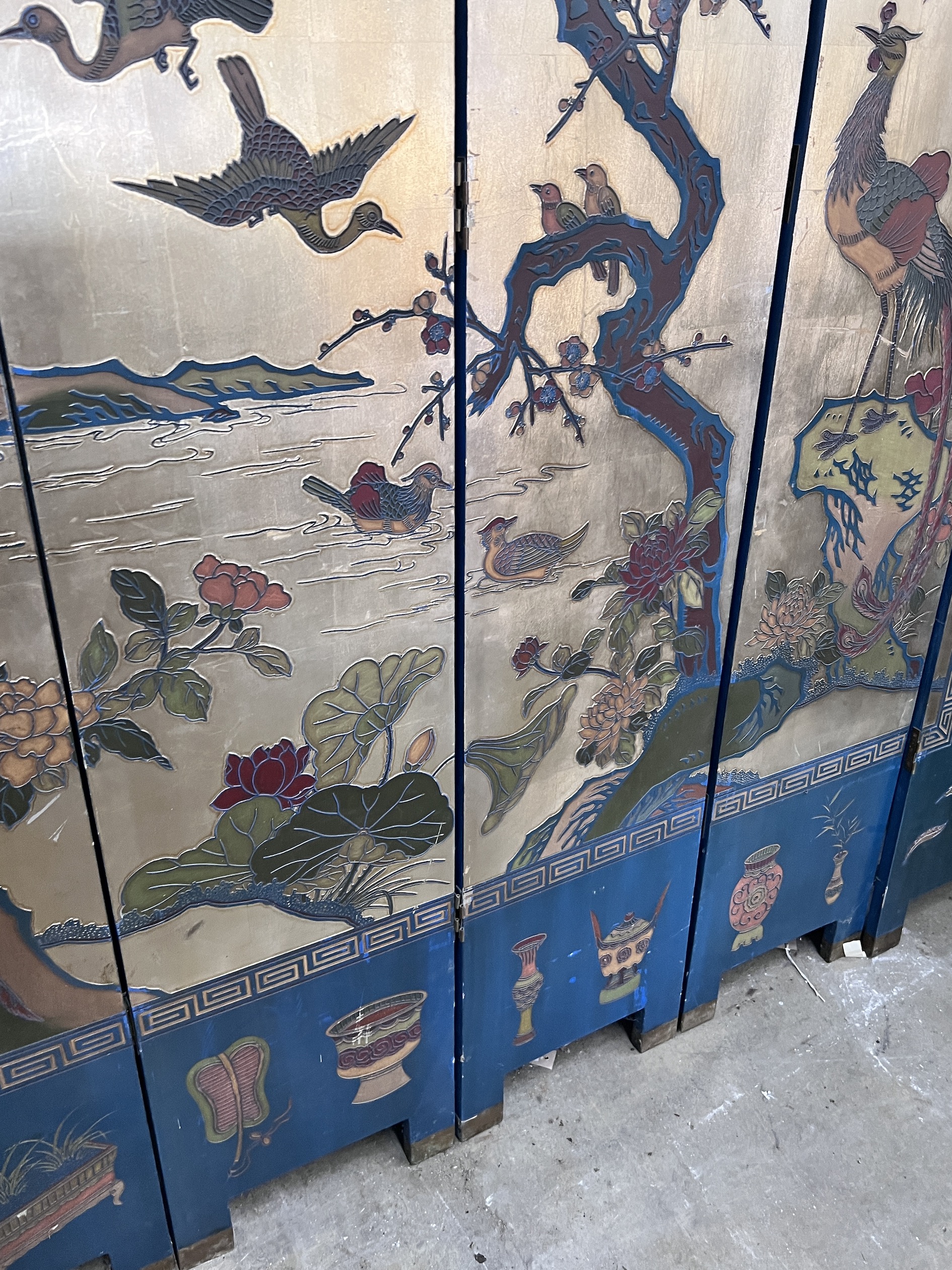 A Chinese lacquered eight fold screen decorated with exotic birds among flowering trees, each panel width 40cm, height 244cm (no fixing clips)